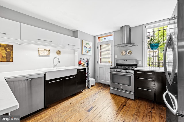 907 Mchenry St, Baltimore, MD 21223 - kitchen featuring stainless steel appliances, wall chimney exhaust hood, light countertops, and a sink