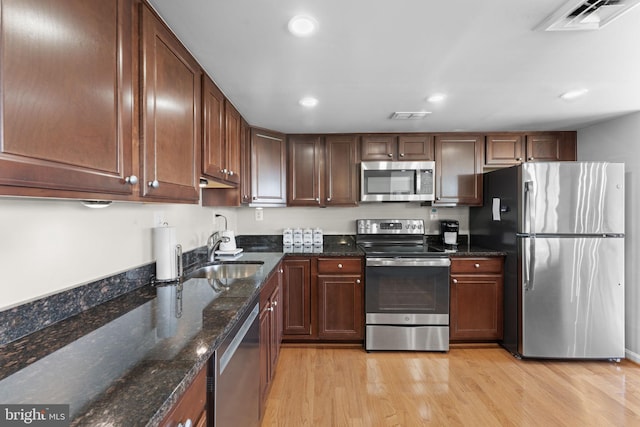 1515 S Arlington Ridge Rd Unit 402, Arlington, VA 22202 - kitchen featuring appliances with stainless steel finishes, light wood-style flooring, recessed lighting, a sink, and dark stone countertops