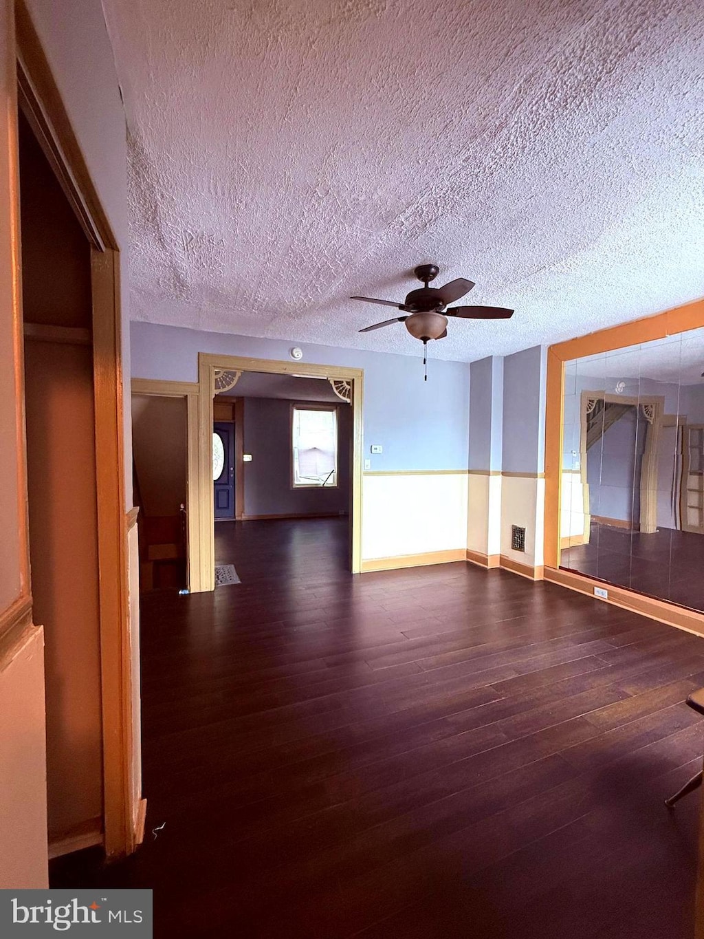619 N Clinton St N, Baltimore, MD 21205 - unfurnished living room with wood finished floors, ceiling fan, and a textured ceiling