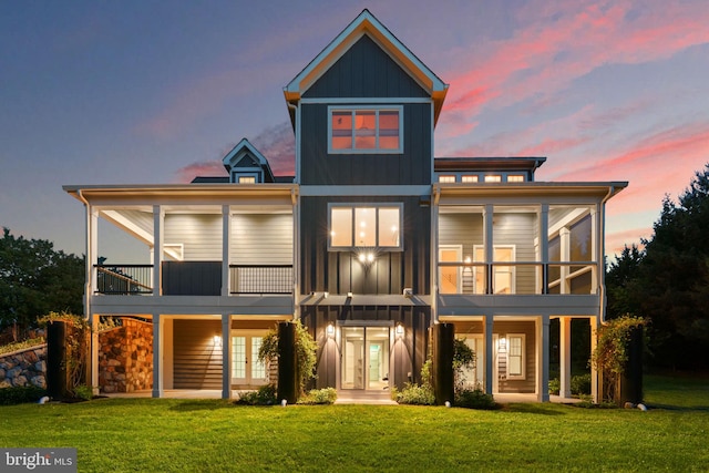 13492 Allnutt Ln, Highland, MD 20777 - back of property at dusk featuring board and batten siding, french doors, a yard, and a balcony