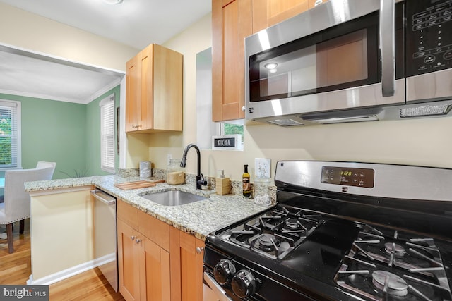 7906 Garland Ave, Takoma Park, MD 20912 - kitchen featuring stainless steel appliances, a sink, crown molding, light wood-style flooring, and light stone counters