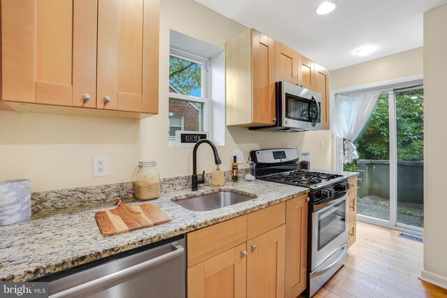 7906 Garland Ave, Takoma Park, MD 20912 - kitchen featuring appliances with stainless steel finishes, a sink, light brown cabinetry, light stone counters, and light wood-type flooring
