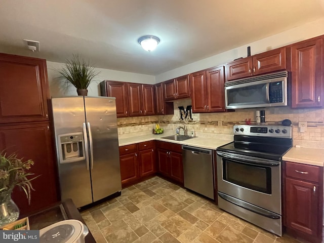 27 Holcumb Ct, Baltimore, MD 21220 - kitchen featuring appliances with stainless steel finishes, a sink, light countertops, tasteful backsplash, and reddish brown cabinets
