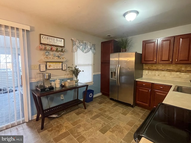 27 Holcumb Ct, Baltimore, MD 21220 - kitchen with stainless steel fridge with ice dispenser, range with electric cooktop, light countertops, backsplash, and stone finish floors