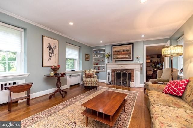 1431 Wheatsheaf Ln, Abington, PA 19001 - living room with wood finished floors, recessed lighting, radiator, a brick fireplace, and ornamental molding