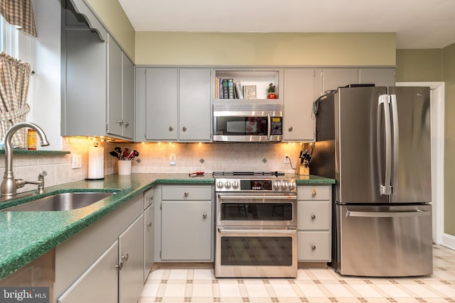1431 Wheatsheaf Ln, Abington, PA 19001 - kitchen with stainless steel appliances, a sink, gray cabinets, tasteful backsplash, and dark countertops