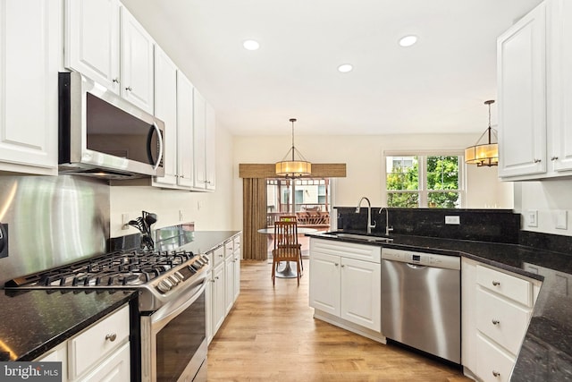 25366 Ashbury, Chantilly, VA 20152 - kitchen featuring appliances with stainless steel finishes, a sink, white cabinets, light wood-style flooring, and a peninsula