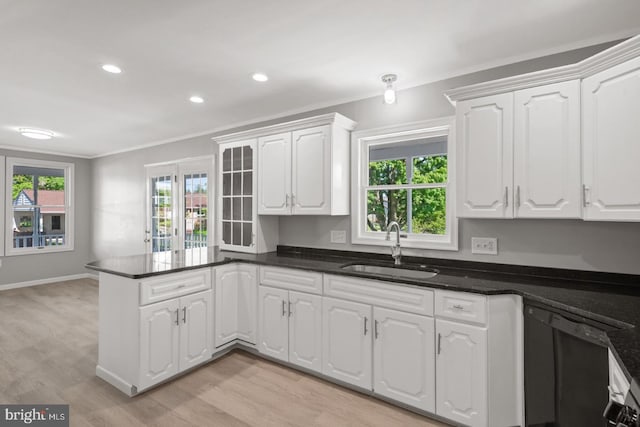 213 Redwood St, Harrisburg, PA 17109 - kitchen with a sink, a peninsula, white cabinetry, black dishwasher, and ornamental molding