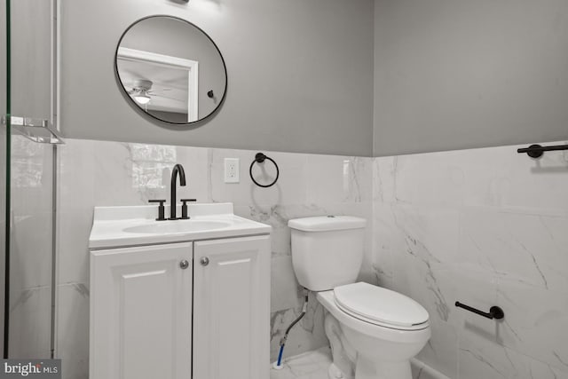 213 Redwood St, Harrisburg, PA 17109 - bathroom featuring tile walls, vanity, toilet, a ceiling fan, and marble look tile flooring