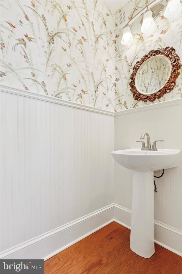 309 Conestoga Rd, Wayne, PA 19087 - bathroom with wallpapered walls, wood finished floors, wainscoting, baseboards, and a sink