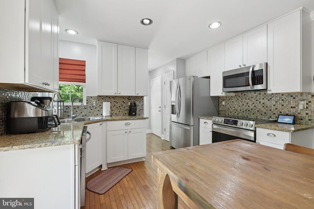 9410 Carleigh Ct, Owings, MD 20736 - kitchen with stainless steel appliances, white cabinetry, light wood-style flooring, and recessed lighting