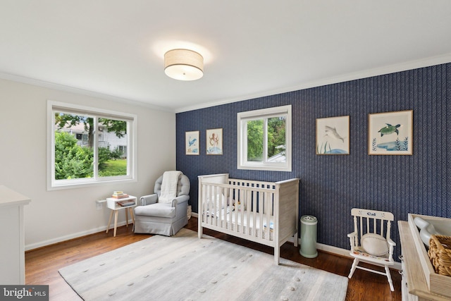 9212 E Parkhill Dr, Bethesda, MD 20814 - bedroom featuring crown molding, wood finished floors, baseboards, a crib, and wallpapered walls