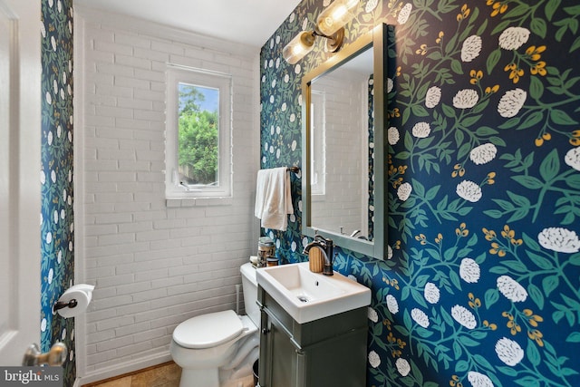 9212 E Parkhill Dr, Bethesda, MD 20814 - half bath with wallpapered walls, toilet, vanity, and brick wall