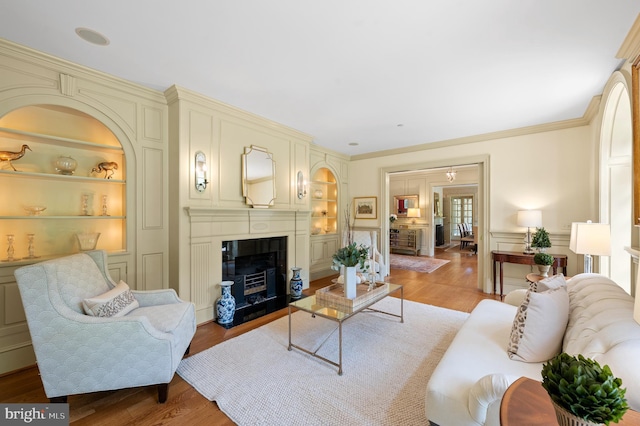 601 Maplewood Rd, Wayne, PA 19087 - living room with built in features, light wood-style floors, a fireplace with flush hearth, and ornamental molding