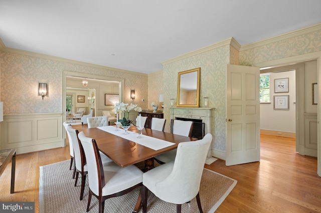 601 Maplewood Rd, Wayne, PA 19087 - dining room featuring wallpapered walls, light wood-type flooring, ornamental molding, a high end fireplace, and a wainscoted wall
