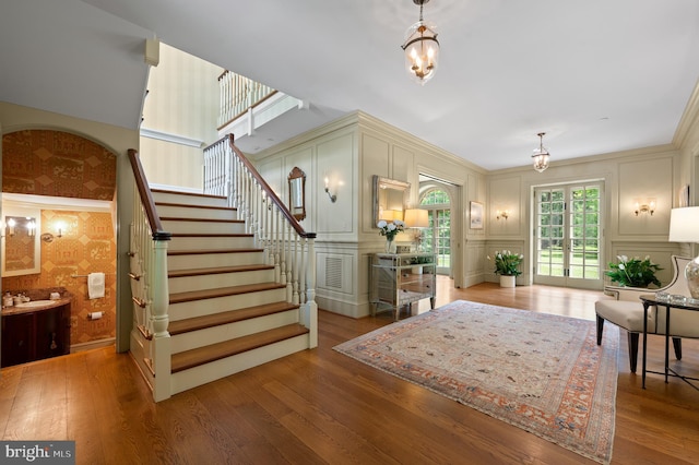 601 Maplewood Rd, Wayne, PA 19087 - entryway featuring a chandelier, a decorative wall, stairs, wood finished floors, and wallpapered walls