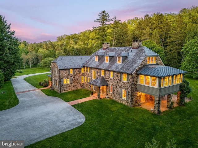 601 Maplewood Rd, Wayne, PA 19087 - view of front facade featuring a high end roof, a chimney, a forest view, a front lawn, and driveway