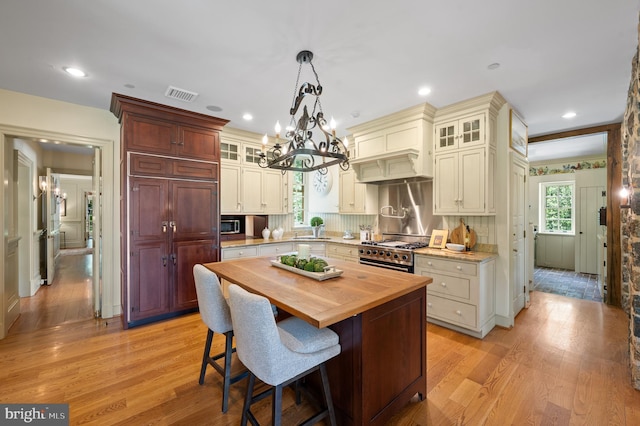 601 Maplewood Rd, Wayne, PA 19087 - kitchen with high end stainless steel range oven, butcher block counters, a sink, a chandelier, and light wood-type flooring