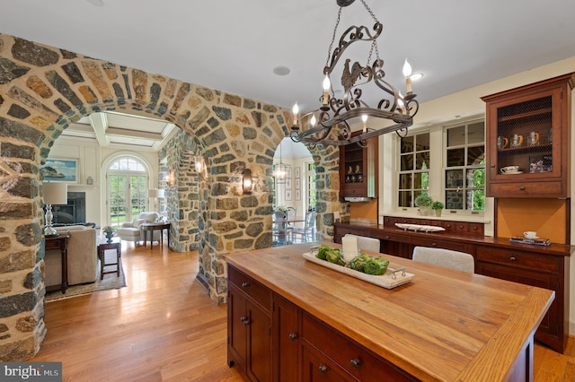 601 Maplewood Rd, Wayne, PA 19087 - dining area with arched walkways, light wood-type flooring, coffered ceiling, a chandelier, and a fireplace