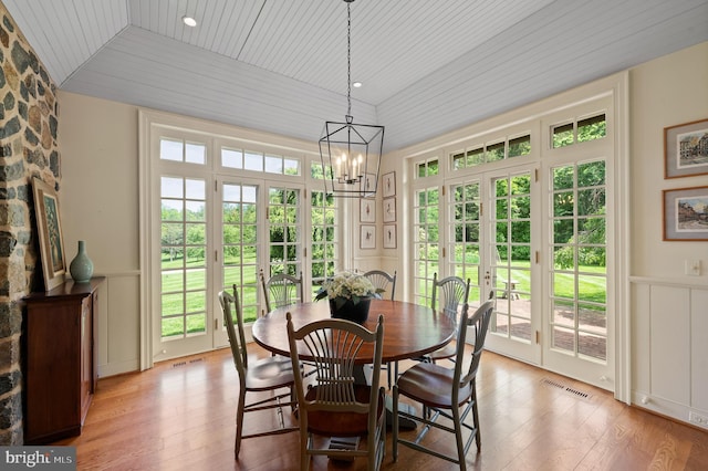 601 Maplewood Rd, Wayne, PA 19087 - dining space featuring a decorative wall, light wood-style flooring, a chandelier, healthy amount of natural light, and wainscoting