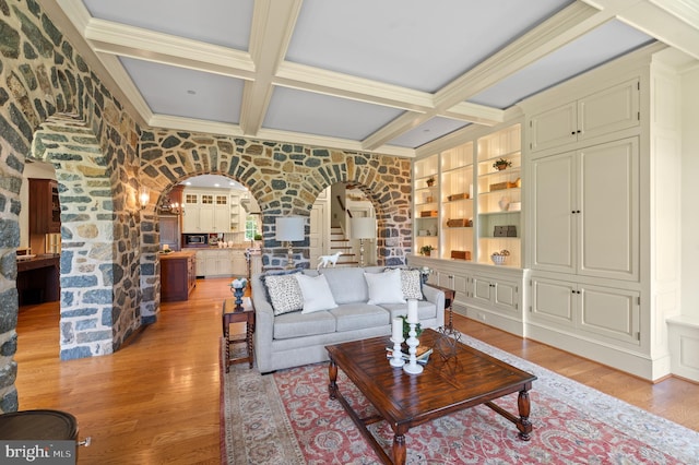601 Maplewood Rd, Wayne, PA 19087 - living area featuring arched walkways, coffered ceiling, light wood finished floors, built in shelves, and beamed ceiling