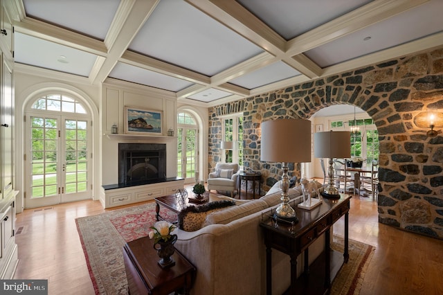 601 Maplewood Rd, Wayne, PA 19087 - living room with arched walkways, light wood finished floors, coffered ceiling, beam ceiling, and a fireplace with raised hearth