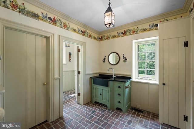 601 Maplewood Rd, Wayne, PA 19087 - kitchen with a sink, brick flooring, green cabinetry, wainscoting, and hanging light fixtures