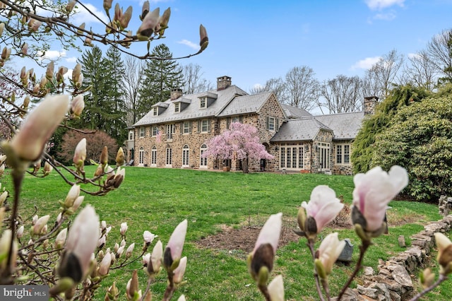 601 Maplewood Rd, Wayne, PA 19087 - back of house with a high end roof, stone siding, a chimney, and a yard