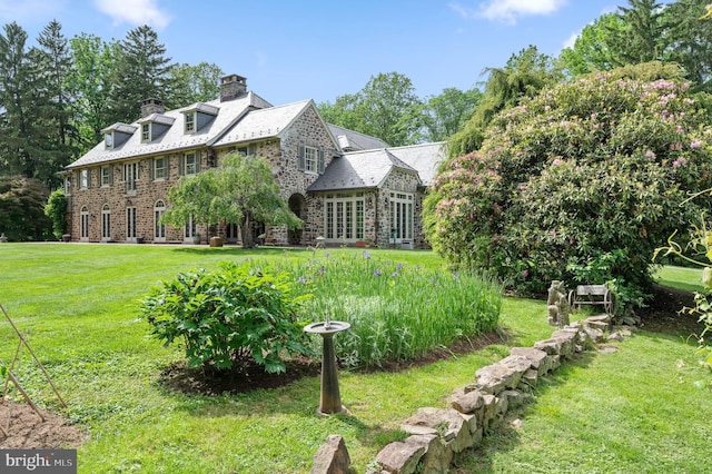 601 Maplewood Rd, Wayne, PA 19087 - view of front of house with a chimney, a front lawn, stone siding, and a high end roof