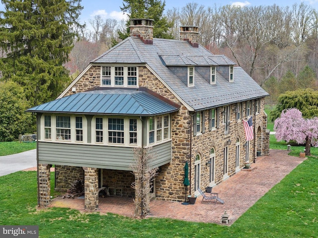 601 Maplewood Rd, Wayne, PA 19087 - back of property with stone siding, a standing seam roof, a yard, and a chimney