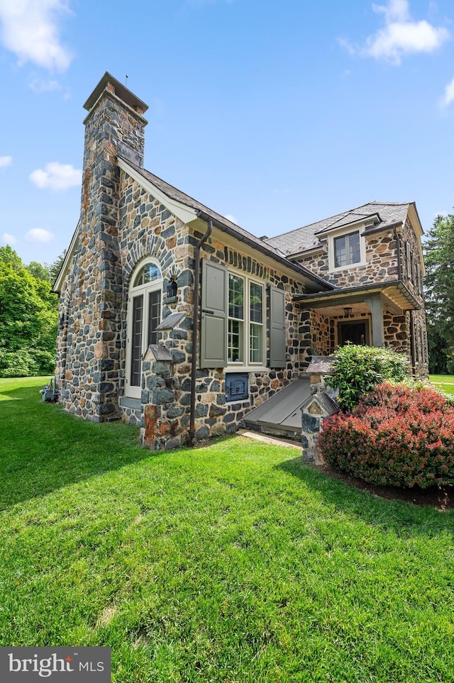 601 Maplewood Rd, Wayne, PA 19087 - back of house featuring stone siding, a lawn, a chimney, and a high end roof