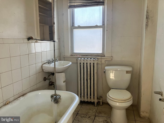 3505 24th St NE, Washington, DC 20018 - full bathroom featuring radiator heating unit, a freestanding tub, healthy amount of natural light, tile patterned flooring, and tile walls