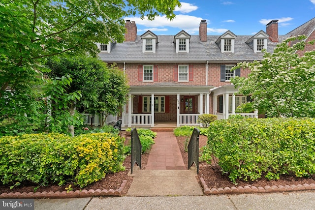 546 W University Pkwy, Baltimore, MD 21210 - view of front of house with brick siding, a high end roof, a porch, and a chimney