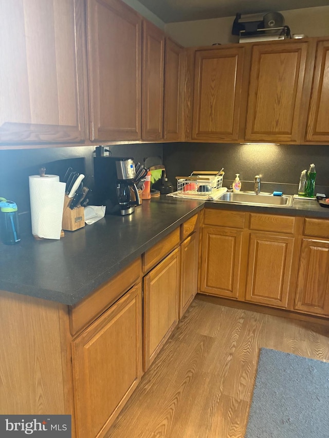 400 Louise Ave, Croydon, PA 19021 - kitchen with a sink, light wood-type flooring, brown cabinets, and dark countertops