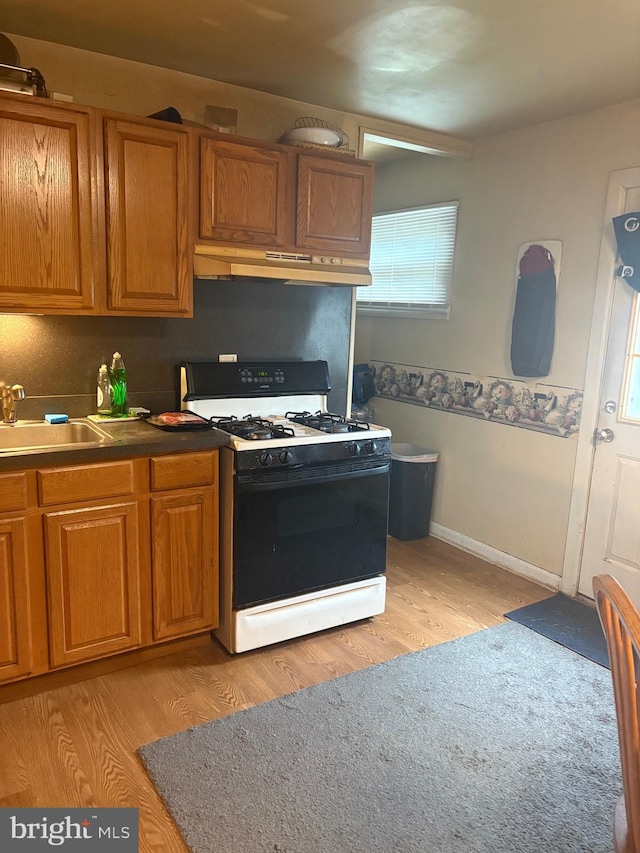 400 Louise Ave, Croydon, PA 19021 - kitchen featuring gas range, a sink, under cabinet range hood, and brown cabinetry