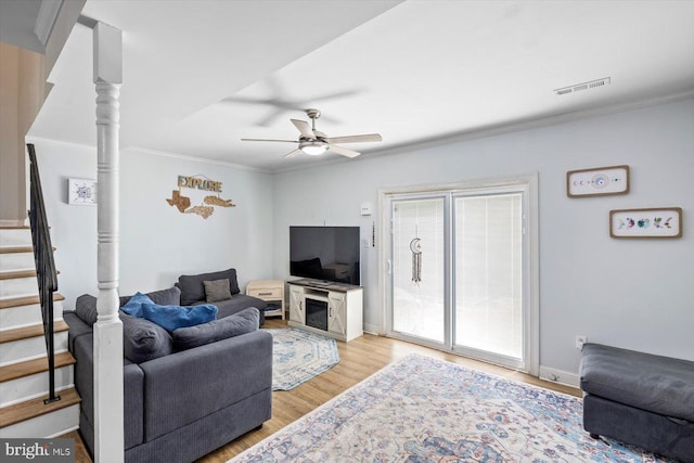 1931 Fort Monroe Ct, Dumfries, VA 22026 - living room featuring crown molding, stairway, ceiling fan, and light wood-type flooring