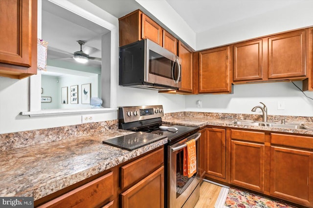 1931 Fort Monroe Ct, Dumfries, VA 22026 - kitchen with appliances with stainless steel finishes, a ceiling fan, brown cabinetry, and light wood-style flooring