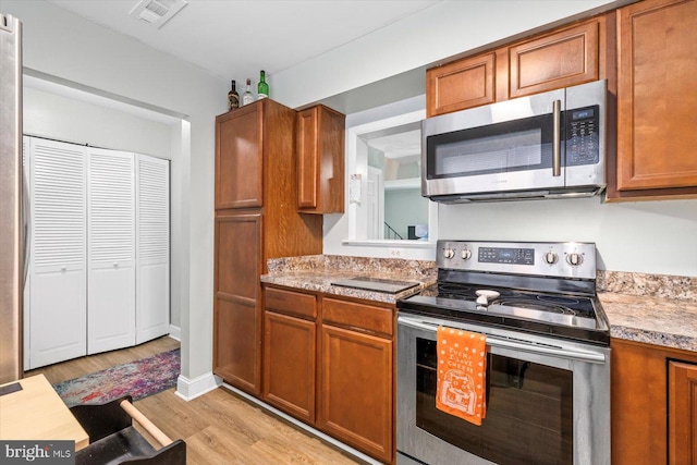 1931 Fort Monroe Ct, Dumfries, VA 22026 - kitchen with appliances with stainless steel finishes, brown cabinets, light countertops, and light wood-style floors