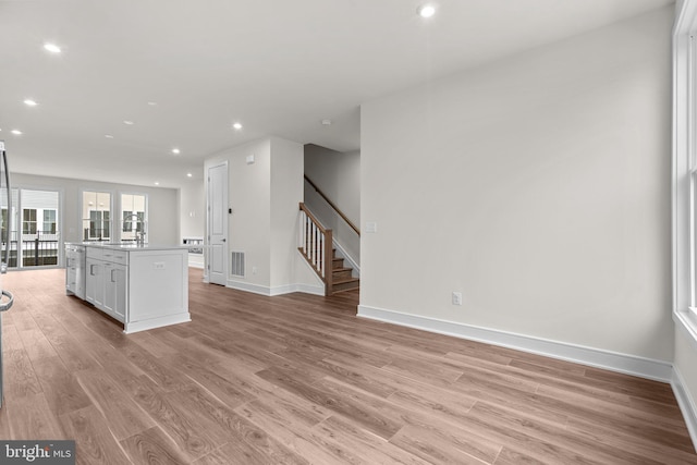 23062 Soaring Heights Ter, Ashburn, VA 20148 - unfurnished living room featuring light wood-style floors, stairway, baseboards, and recessed lighting
