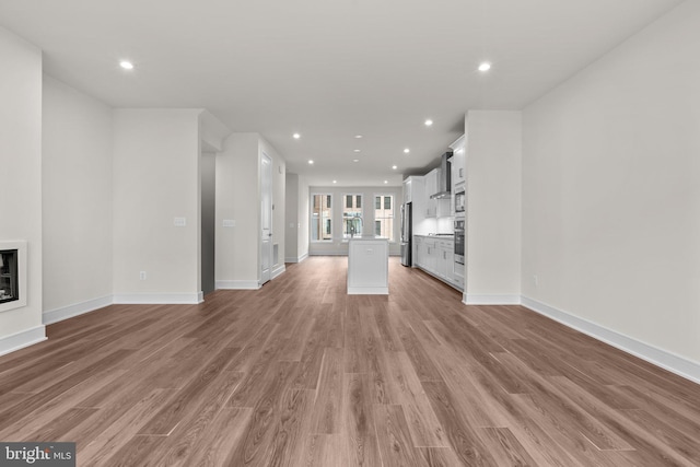 23062 Soaring Heights Ter, Ashburn, VA 20148 - unfurnished living room with a glass covered fireplace, light wood-style floors, recessed lighting, and baseboards