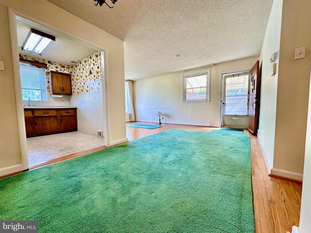 8128 Lister St, Philadelphia, PA 19152 - unfurnished living room with healthy amount of natural light, a textured ceiling, wood finished floors, and baseboards