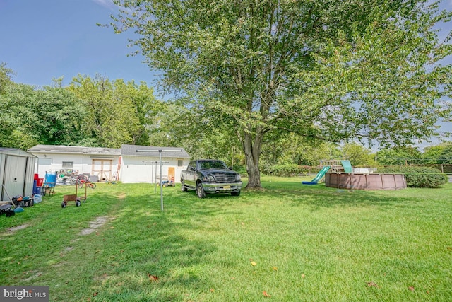 28 Malaga Ter, Malaga, NJ 08328 - view of grassy yard featuring a playground and view of wooded area