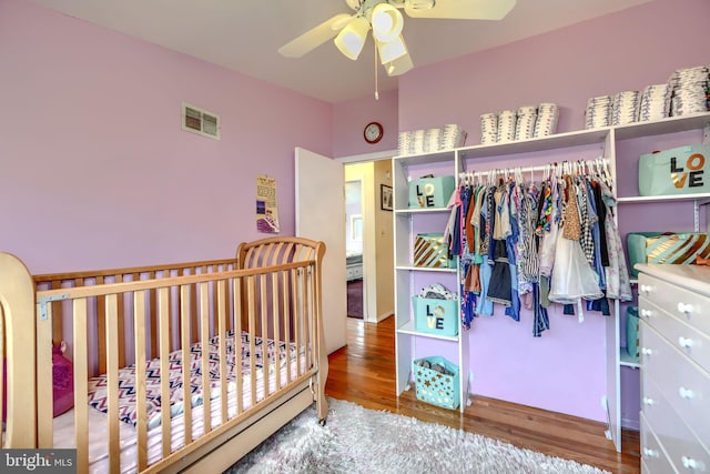 2409 Lightfoot Dr, Baltimore, MD 21209 - bedroom with wood finished floors, ceiling fan, and a crib