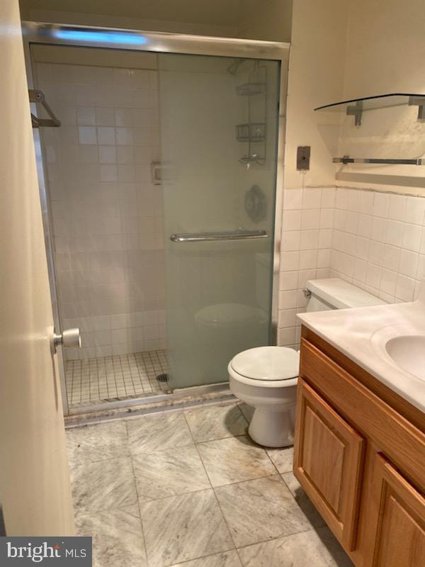 224 W Rittenhouse Sq Unit 2701, Philadelphia, PA 19103 - bathroom featuring a shower stall, vanity, and tile walls