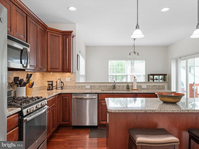 83 Clarence Ave, Severna Park, MD 21146 - kitchen featuring stainless steel appliances, a sink, dark wood finished floors, a breakfast bar area, and decorative backsplash