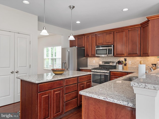 83 Clarence Ave, Severna Park, MD 21146 - kitchen with stainless steel appliances, decorative backsplash, decorative light fixtures, light stone countertops, and dark wood finished floors