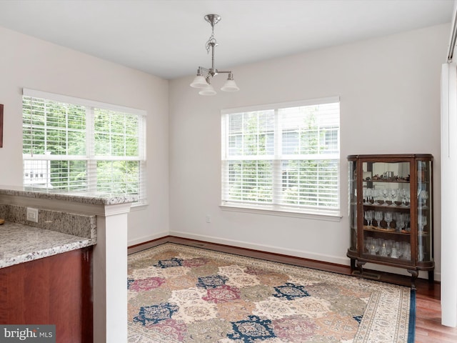 83 Clarence Ave, Severna Park, MD 21146 - unfurnished dining area with wood finished floors, a chandelier, and baseboards