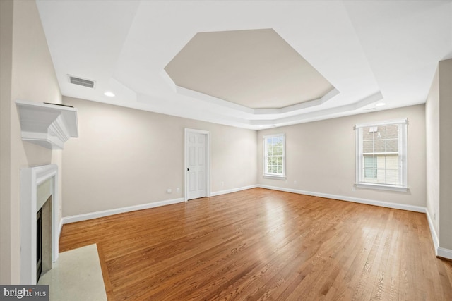 1 Derbyshire Way, Wilmington, DE 19807 - unfurnished living room featuring a raised ceiling, light wood-type flooring, a fireplace with flush hearth, and recessed lighting