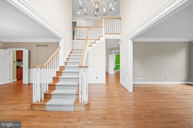 1 Derbyshire Way, Wilmington, DE 19807 - stairway with ornamental molding, a chandelier, wood finished floors, and a towering ceiling