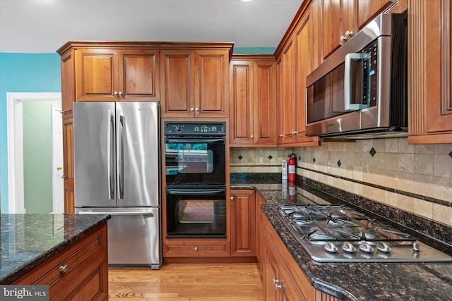 1 Derbyshire Way, Wilmington, DE 19807 - kitchen featuring stainless steel appliances, brown cabinets, tasteful backsplash, and dark stone counters